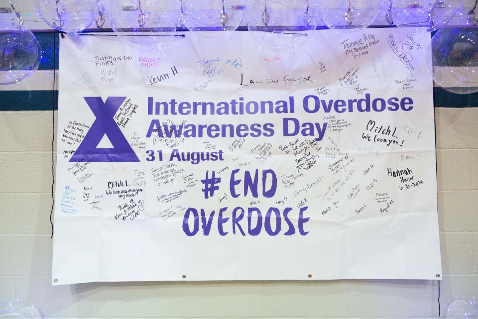 Attendees write down the names of loved ones who have passed away from drug overdoes during the International Overdose Awareness Day fair inside the Westwood Community Center in Jackson, Tennessee on Aug. 31, 2023.