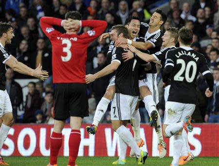 Southampton's Rickie Lambert (C) celebrates with team mate Maya Yoshida, after scoring their third goal against Cardiff City during their English Premier League soccer match at Cardiff City Stadium, Wales, December 26, 2013. REUTERS/Rebecca Naden