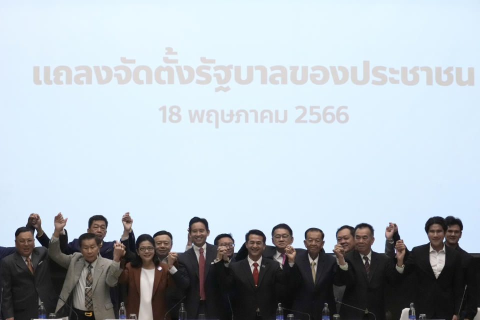 Leader of Move Forward Party Pita Limjaroenrat, fourth from left in front, raises his hands with other seven party leaders, during a press conference in Bangkok, Thailand, Thursday, May 18 , 2023. Thailand's election winner Move Forward Party on Thursday announced an 8-party coalition that its leader declared will become a "democratic government of the people. (AP Photo/Sakchai Lalit)