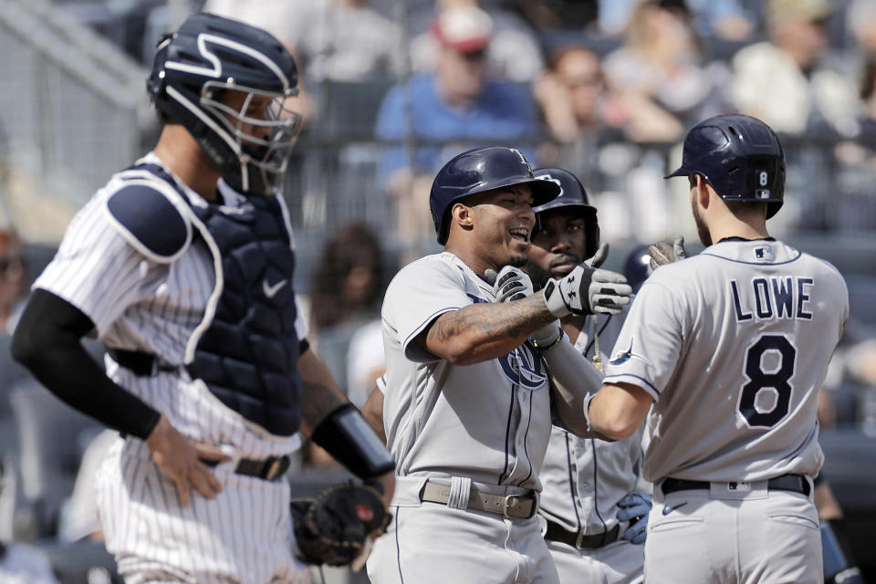 Tampa Bay Rays' Brandon Lowe (8) is congratulated by Wander Franco after hitting a 3-run home run in front of New York Yankees catcher Gary Sanchez during the first inning of a baseball game on Saturday, Oct. 2, 2021, in New York. (AP Photo/Adam Hunger)