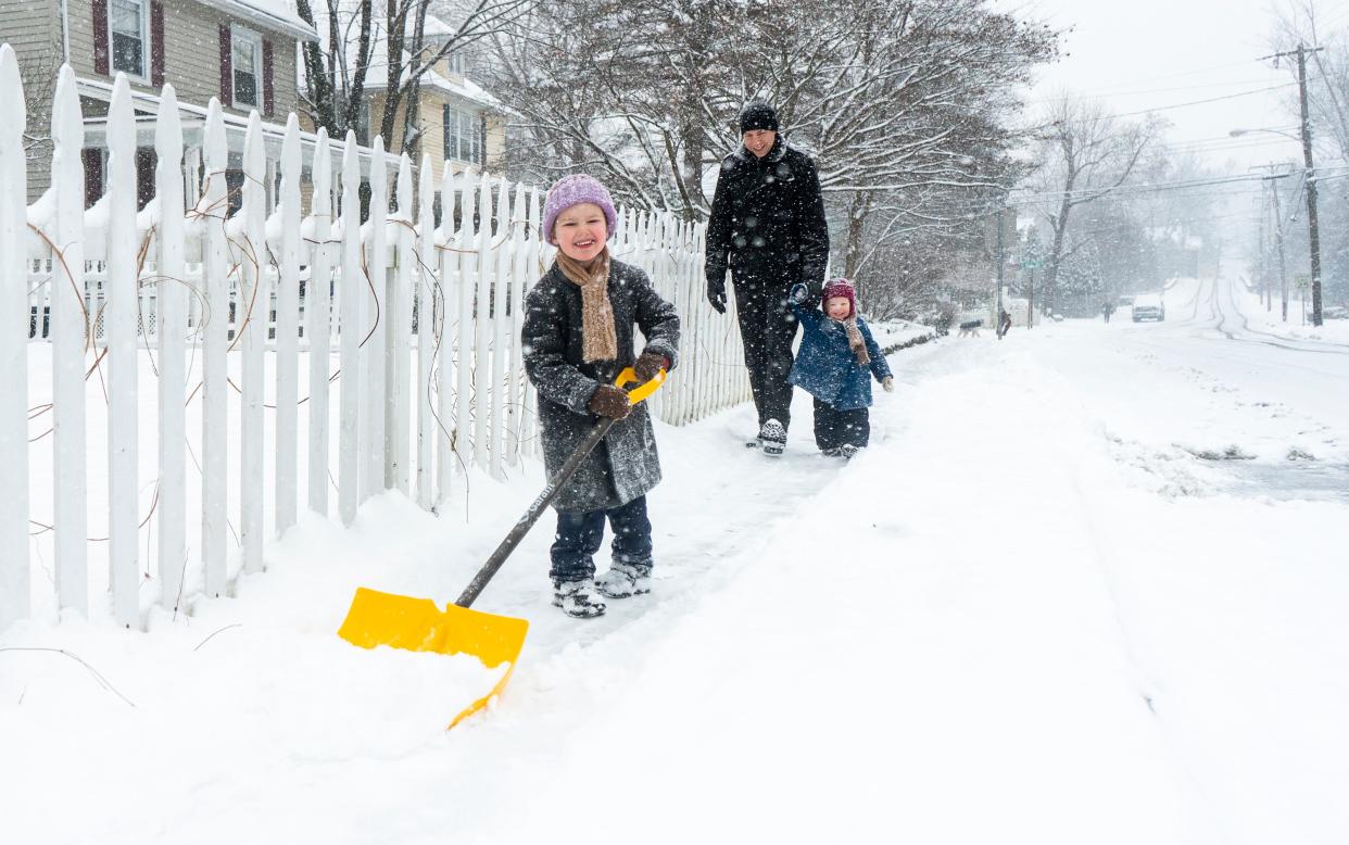 William Hagenbuch (4), in front, helps to shovel the sidewalk with Andrew Hagenbuch, center, and Henry Hagenbuch (21 months), from Yardley, along E. College Ave. as snow continues to fall in Yardley on Friday, Jan. 19, 2024.

Daniella Heminghaus | Bucks County Courier Times