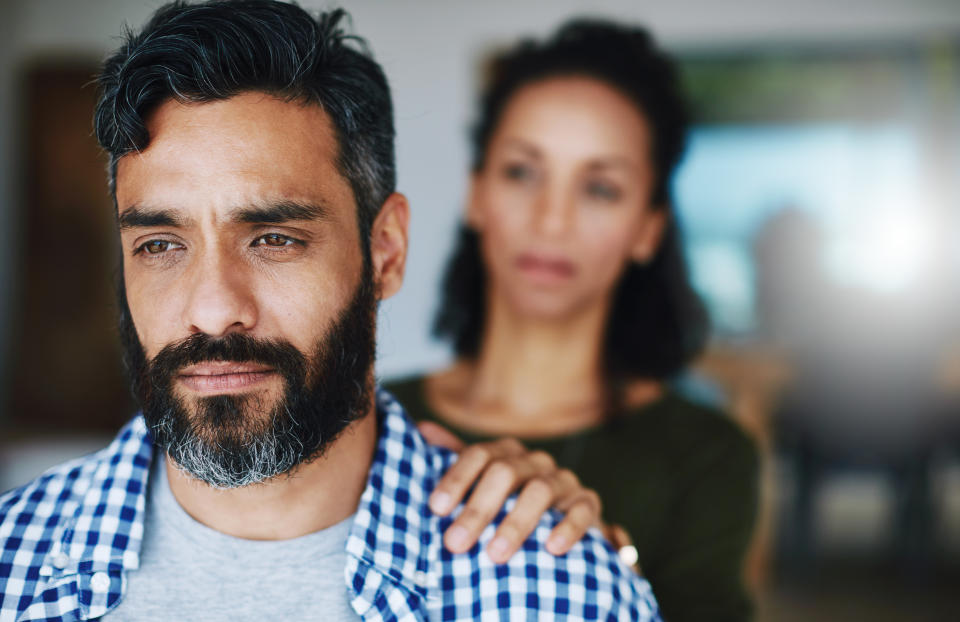 Shot of a woman comforting her distraught husband at home. (Getty Creative)