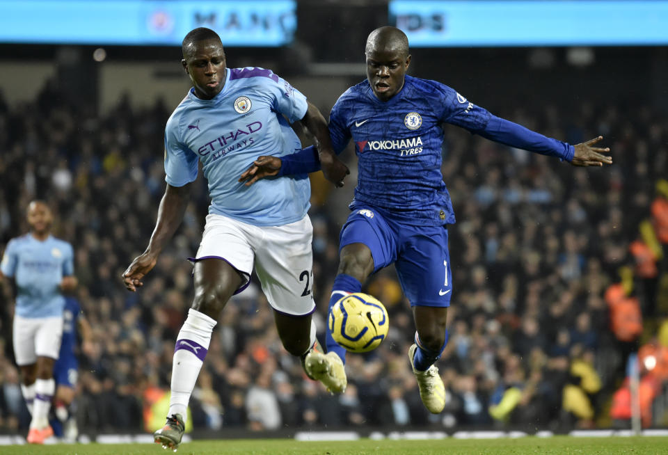 Chelsea's N'Golo Kante, right, controls the ball to shoot and score the opening goal nest to Manchester City's Benjamin Mendy, left, during the English Premier League soccer match between Manchester City and Chelsea at Etihad stadium in Manchester, England, Saturday, Nov. 23, 2019. (AP Photo/Rui Vieira)