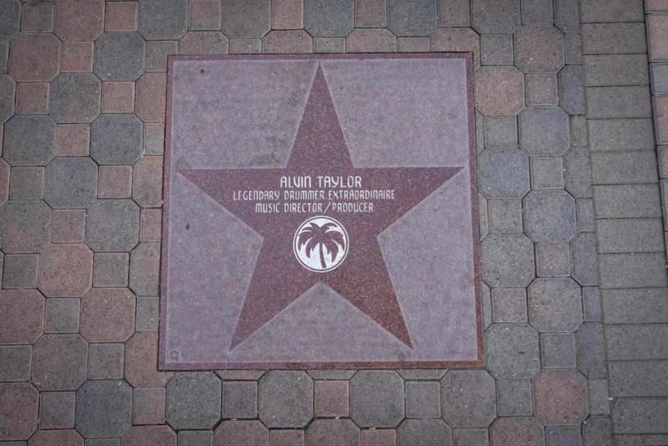 A star with writing on it on a sidewalk.