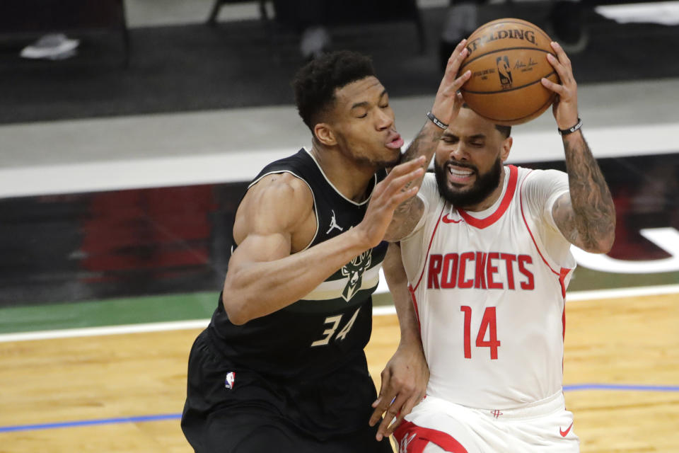 Houston Rockets' D.J. Augustin (14) drives to the basket against Milwaukee Bucks' Giannis Antetokounmpo (34) during the first half of an NBA basketball game Friday, May 7, 2021, in Milwaukee. (AP Photo/Aaron Gash)