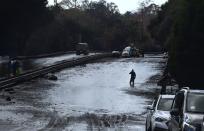 <p>A man wades in a flooded section of the US 101 freeway near the San Ysidro exit in Montecito, California on Jan. 9, 2018.<br> (Photo: Frederic J. Brown/AFP/Getty Images) </p>