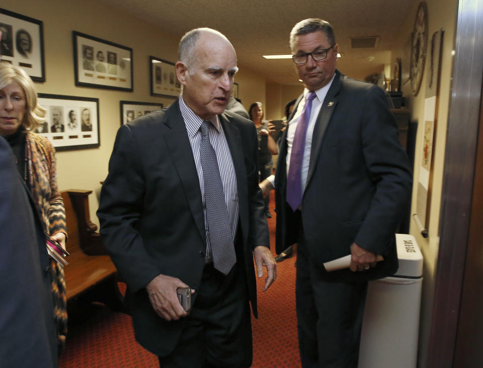 Gov. Jerry Brown walks into a meeting of the Senate Democratic Caucus to urge them to approve a transportation plan,Thursday, April 6, 2017, in Sacramento, Calif. Brown and top legislative leaders pressed all week to convince fellow Democrats to support the measure that would place a $5-billion-a-year boost in California's gas and vehicle taxes to pay for major road repairs. (AP Photo/Rich Pedroncelli)