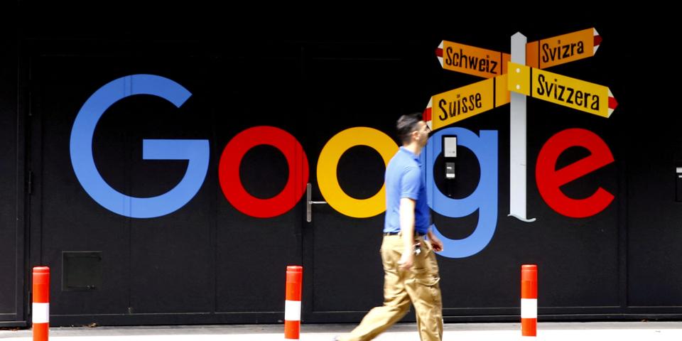 A man walks past a logo of Google in Zurich, Switzerland.