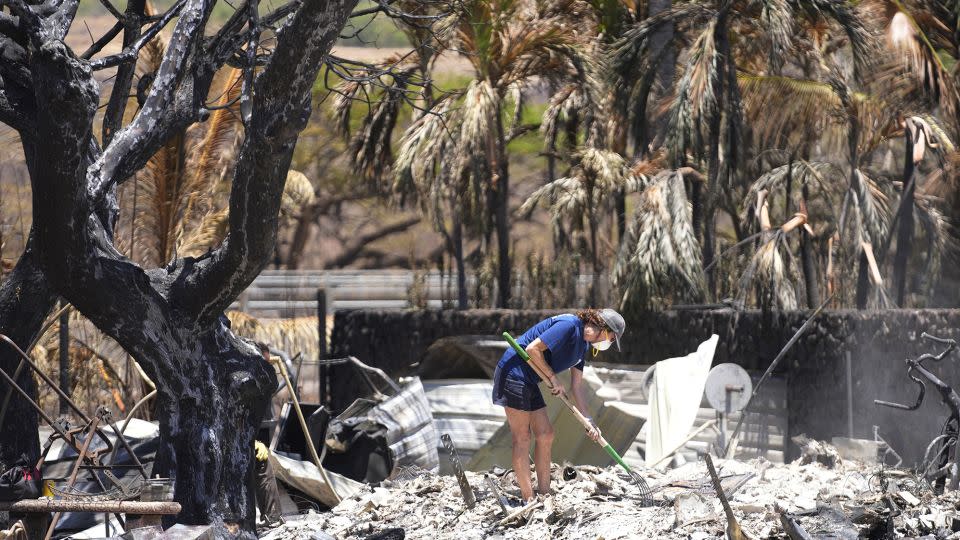 A woman digs through rubble of a home destroyed by a wildfire on Friday, Aug. 11, 2023, in Lahaina, Hawaii.  - Rick Bowmer/AP