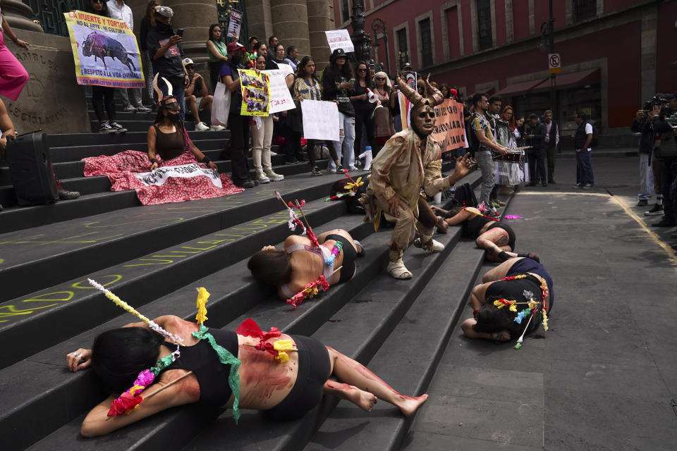 Activistas por los derechos de los animales, pintados con sangre falsa y portando banderillas para simular los toros en una corrida, protestan contra la lidia del animal, en la Ciudad de México, el 14 de febrero de 2024. (AP Foto/Marco Ugarte)