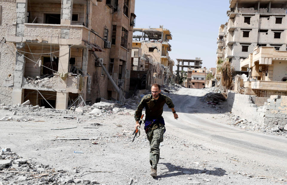 <p>A British volunteer fighter of Syrian Democratic Forces runs for cover to avoid sniper fire of Islamic State militants, at the frontline in Raqqa, Syria, Oct. 7, 2017. (Photo: Erik De Castro/Reuters) </p>