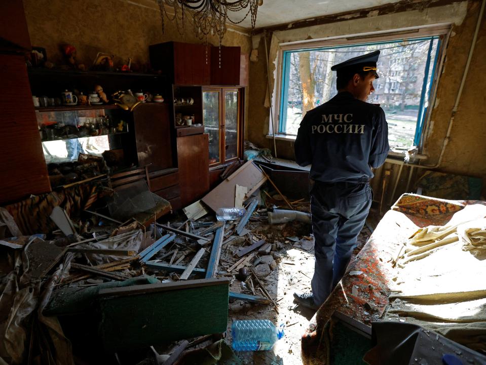 A member of Russia’s emergencies ministry inspects a flat damaged by shelling in what Russian-installed authorities called a Ukrainian military strike (Reuters)