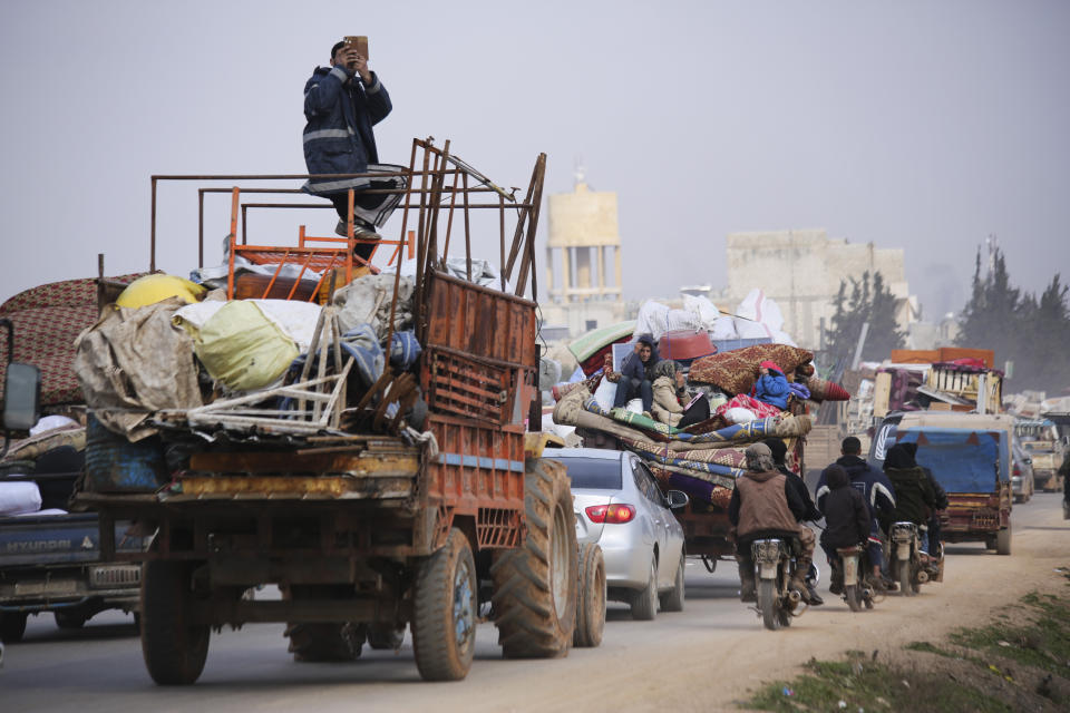File - In this Monday, Jan. 27, 2020 file photo, Syrian refugees head northwest through the town of Hazano in Idlib province as the flee renewed fighting. Syrians are marking 10 years since peaceful protests against President Bashar Assad's government erupted in March 2011, touching off a popular uprising that quickly turned into a full-blown civil war. (AP Photo/Ghaith Alsayed, File)