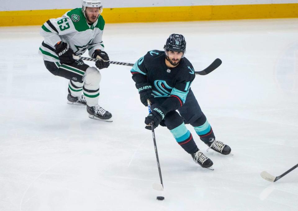 Seattle Kraken center Matty Beniers (10) moves the puck down the ice as Dallas Stars right wing Evgenii Dadonov (63) defends during the first period of game four of the second round of the 2023 Stanley Cup Playoffs in Seattle, Wash. on May 9, 2023.
