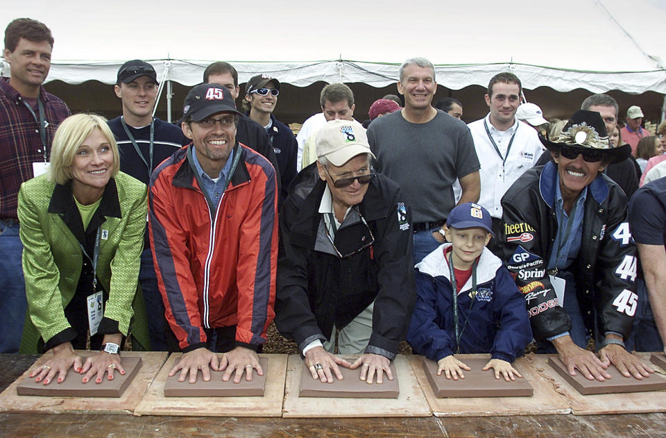 FILE - Pattie Petty, Kyle Petty, Paul Newman, Haleigh Epperson and Richard Petty, from left, pose with NASCAR drivers as they press their hands into clay blocks during a ceremony to commemorate the beginning of construction of the Victory Junction Gang Camp Tuesday Oct. 8, 2002, in Randleman, N.C. Adam Petty was 19 when he was killed in a crash practicing for a race at New Hampshire. Not too many years before, he'd made a visit to Paul Newman's-owned Camp Boggy Creek and became transfixed in creating a similar camp in North Carolina for children with serious medical issues. Richard Petty, onsidered NASCAR's greatest driver, said the family following through on Adam's dream with be their lasting legacy. (AP Photo/Chuck Burton, File)