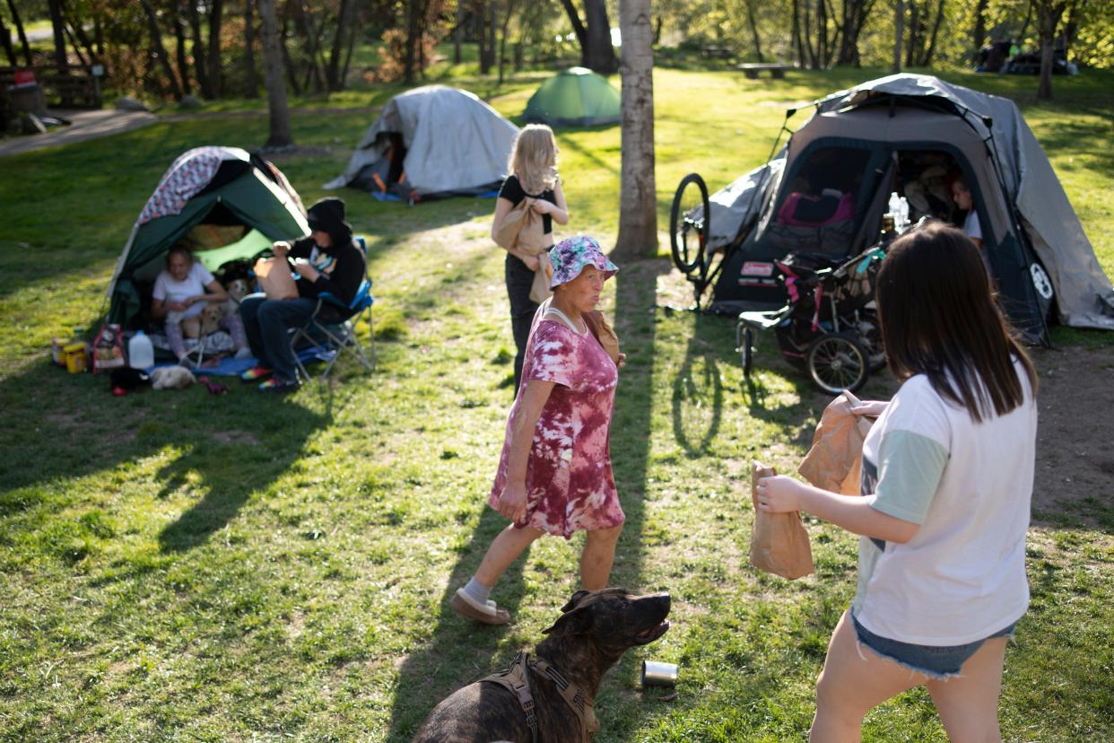 “We’re not all bad. We’re not alcoholics. We’re not on drugs. There are a lot of reasons why we’re out here,” said Kimberly Morris who has been unhoused for six months. She walks through an unhoused camp in Tussing Park in Grants Pass, Ore. on April 10. Morris is one of hundreds living unhoused in Grants Pass that could be affected by the Supreme Court as it hears arguments in late April on an ordinance that could criminalize camping in the city’s public parks.