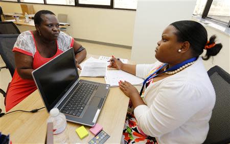 Certified Application Counselor Sheslie Caze (R) takes information from a woman who asked not to be identified as she inquired about the Affordable Care Act insurance, commonly referred to as Obamacare, at the Borinquen Medical Center in Miami, Florida October 1, 2013. REUTERS/Joe Skipper