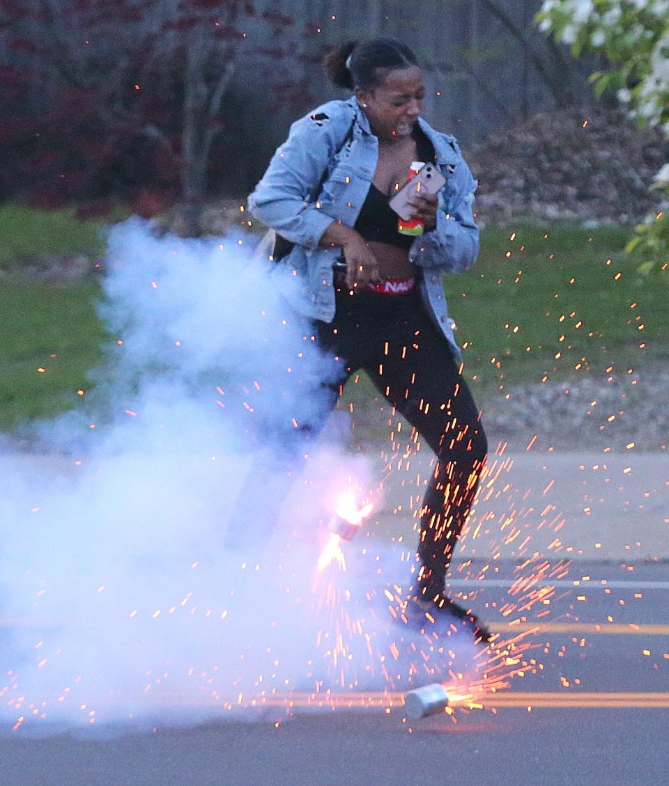 A Jayland Walker protester dodges a chemical canister deployed by Akron police officers on Copley Road on Wednesday to break up a protest over the shooting death of Jayland Walker by police.