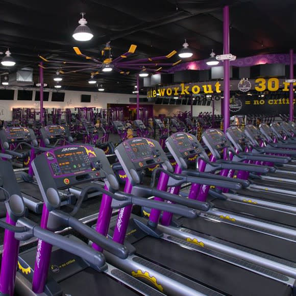 Row of treadmills inside a Planet Fitness location