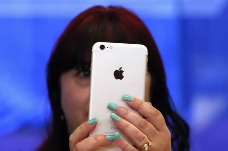 A woman holds an iPhone 6 Plus after it went on sale at the Apple store in Sydney September 19, 2014. REUTERS/David Gray