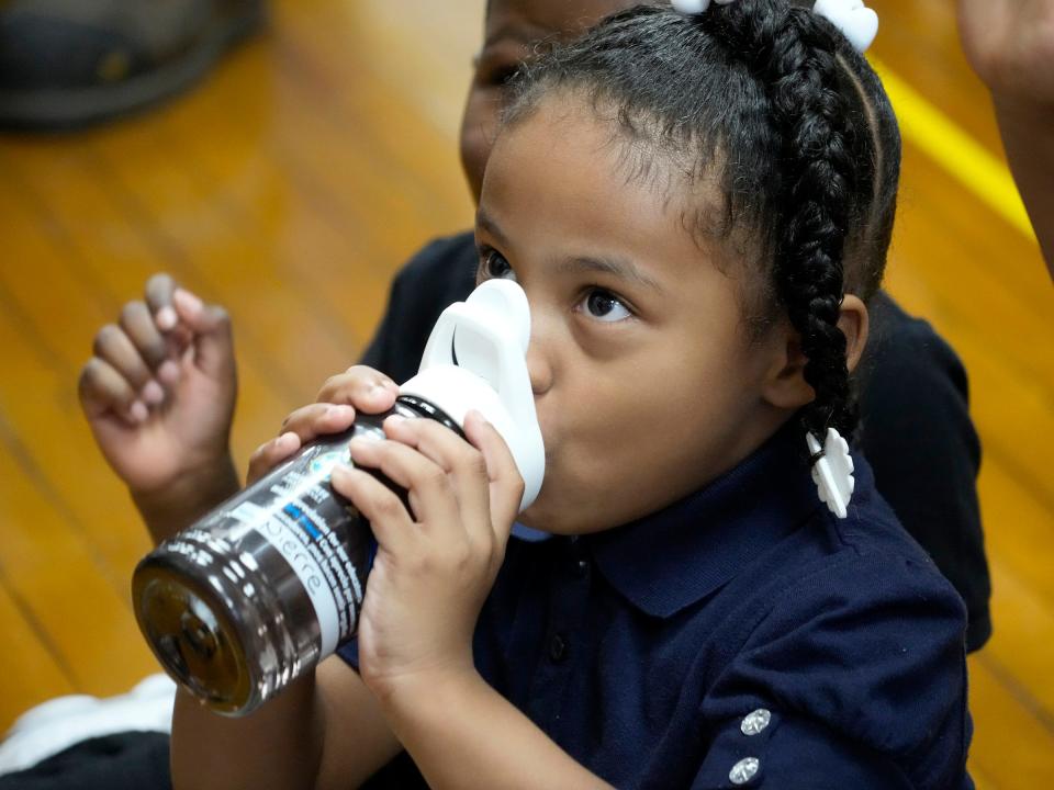 A Frances Brock Starms Early Childhood Center student drinks from her water bottle filled at the new filtered drinking fountain at the school on West Garfield Avenue in Milwaukee on Monday. Milwaukee Public Schools has installed nearly 600 new Elkay filtered bottle filling stations.