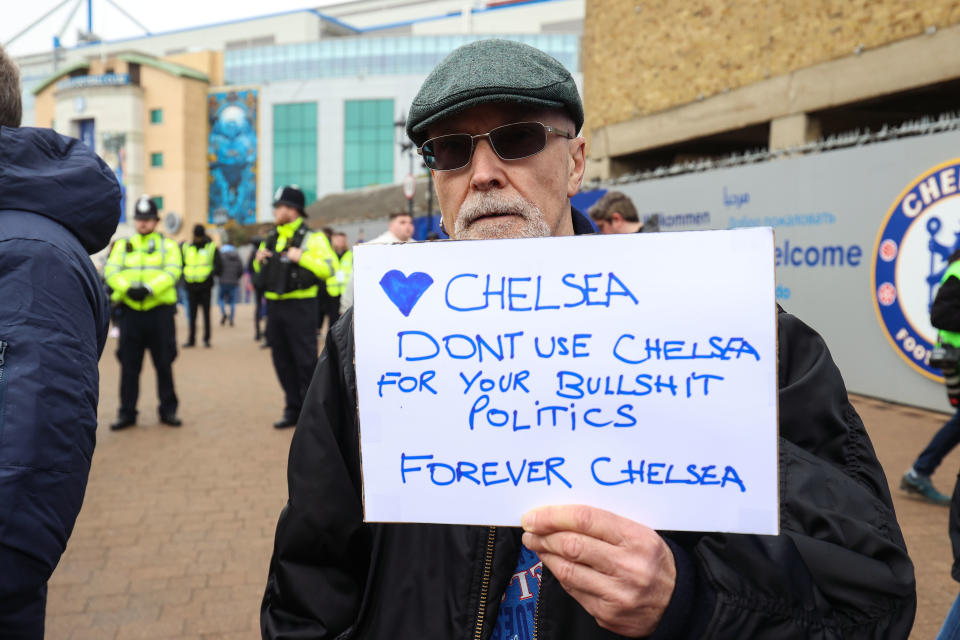 A Chelsea fan, pictured here holding a sign in support of the club outside Stamford Bridge.