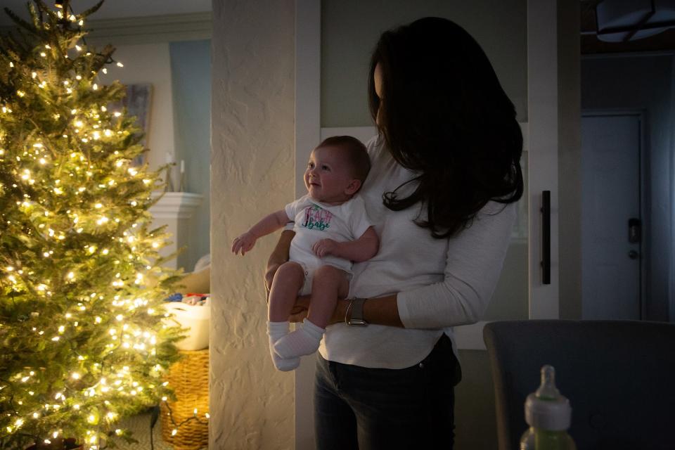 Christina Lambert holds her daughter Brianna at her home in West Palm Beach on December 12, 2023.