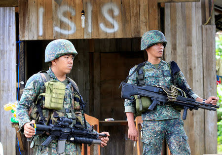 Soldiers stand guard along the main street of Mapandi village as government troops continue their assault on insurgents from the Maute group, who have taken over large parts of Marawi City, Philippines June 2, 2017. REUTERS/Romeo Ranoco