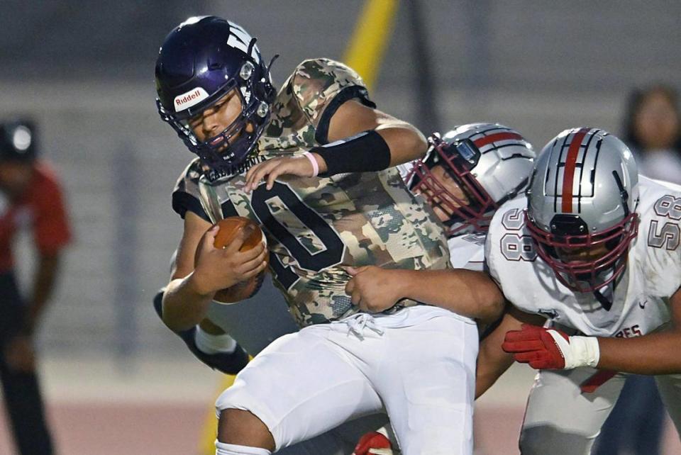 Washington Union quarterback Jason Torres is sacked by Torres High’s Bryan Gonzales, center, with help from Raymond Marroquin, right, Friday, Sept. 1, 2023 in Easton.
