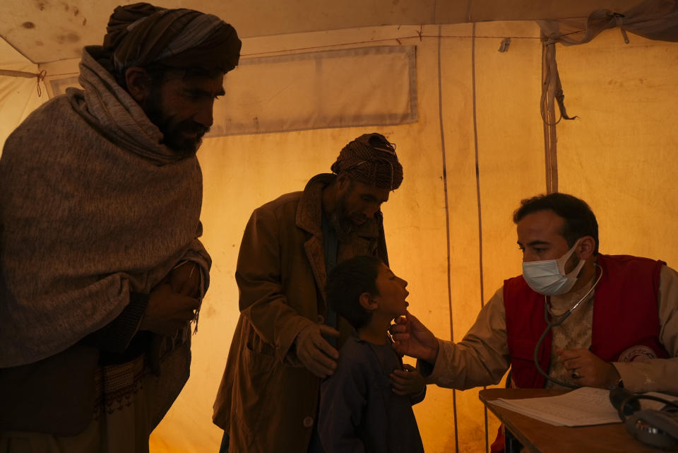 Medic examines sick boy in the makeshift clinic organised by IFRC in the IDP camp near Qala-e-Naw, Afghanistan, Tuesday, Dec. 14, 2021. Severe drought has dramatically worsened the already desperate situation in Afghanistan forcing thousands of people to flee their homes and live in extreme poverty. Experts predict climate change is making such events even more severe and frequent. (AP Photo/Mstyslav Chernov)