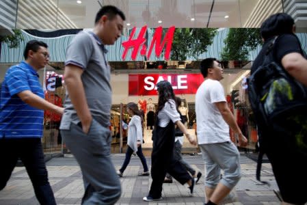 FILE PHOTO: People walk past a H&M fashion chain store at Tsim Sha Tsui shopping district in Hong Kong, China August 1, 2016.  REUTERS/Tyrone Siu/File Photo