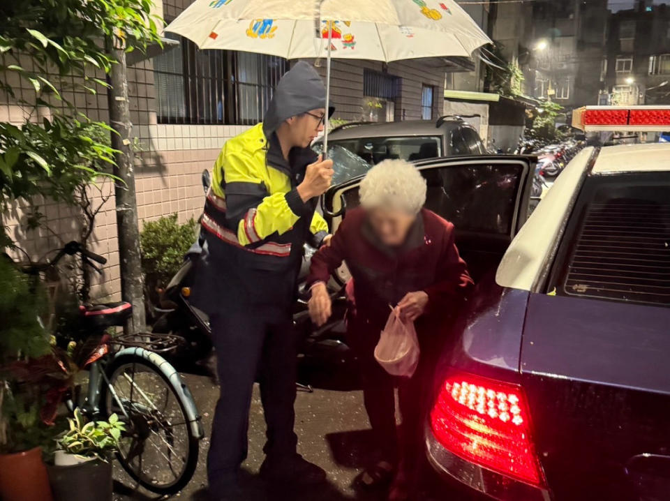 中和警吳聲廷為了不讓李婦在寒冷的天氣下又淋到雨，便在一旁為李婦撐傘送其平安返家。 （圖/記者 張泓笙翻攝）