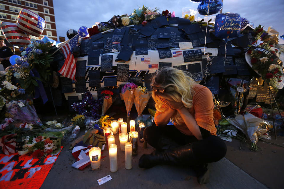 Tasha Lomoglio, of Dallas, cries after lighting candles at a makeshift memorial in honor of the slain Dallas police officers