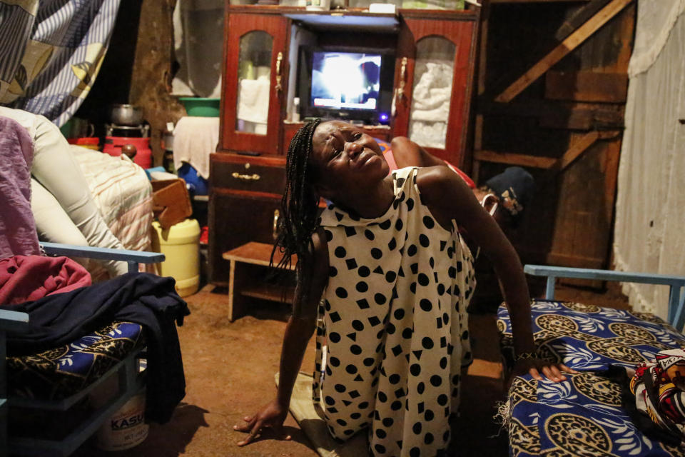 Veronica Atieno endures labor pains as traditional birth attendant Emily Owino, behind, assists her in Emily's one-room house during a dusk-to-dawn curfew, in the Kibera slum of Nairobi, Kenya in the early hours of Friday, May 29, 2020. Kenya already had one of the worst maternal mortality rates in the world, and though data are not yet available on the effects of the curfew aimed at curbing the spread of the coronavirus, experts believe the number of women and babies who die in childbirth has increased significantly since it was imposed mid-March. (AP Photo/Brian Inganga)