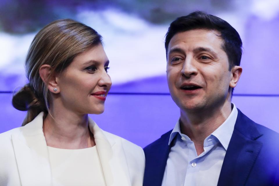 Ukrainian comedian and presidential candidate Volodymyr Zelenskiy, and his wife Olena Zelenska smile as they greet supporters at his headquarters after the second round of presidential elections in Kiev, Ukraine, Sunday, April 21, 2019. Ukrainians voted on Sunday in a presidential runoff as the nation's incumbent leader struggles to fend off a strong challenge by a comedian who denounces corruption and plays the role of president in a TV sitcom. (AP Photo/Sergei Grits)