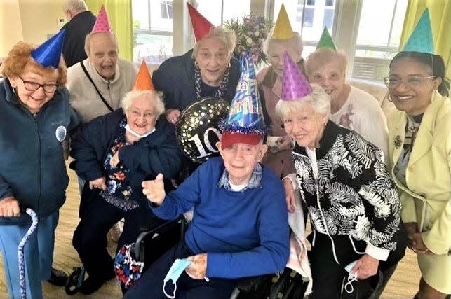 Bill Begley, front and center, celebrates his 100th birthday with friends from the Weymouth Senior Center at the Dwyer Home in Weymouth, where he lives.