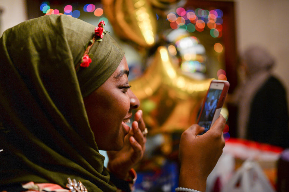 Halima Mahuoud, a Togolese Ghanaian American Muslim, smiles as she photographs her Egyptian American Muslim friend cutting cake at her graduation celebration and Iftar feast during Ramadan in Bayonne, New Jersey, U.S. June 2, 2017. Picture taken June 2, 2017. REUTERS/Amr Alfiky