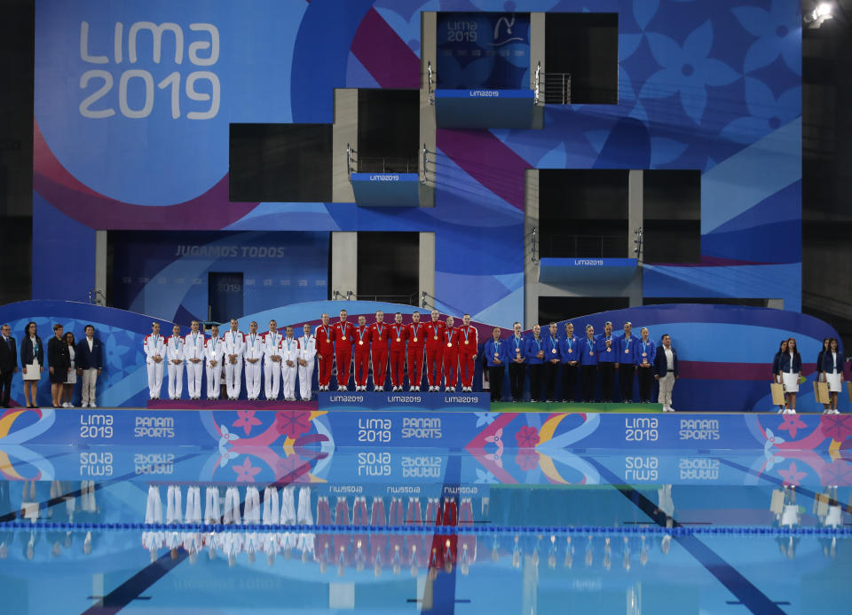 Gold medalists of Canada, center, silver of Mexico, left, and bronze of the United States, listen to Canada's national anthem after the finals of team competition free artistic swimming at the Pan American Games in Lima, Peru, Wednesday, July 31, 2019. (AP Photo/Moises Castillo)