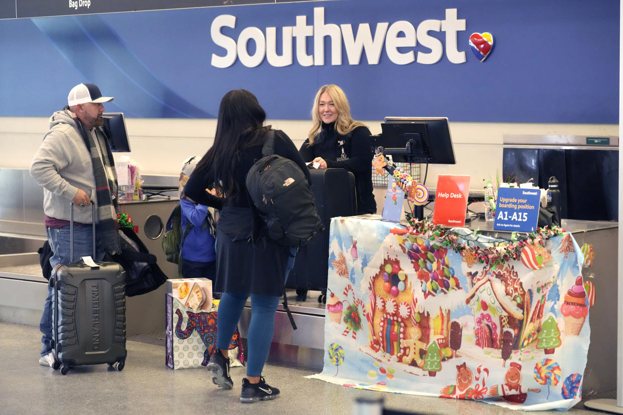 Southwest Airlines ticketing agent Karen, helps a departing family at Chicago's Midway Airport just days before a major winter storm Tuesday, Dec. 20, 2022, in Chicago. (AP Photo/Charles Rex Arbogast)