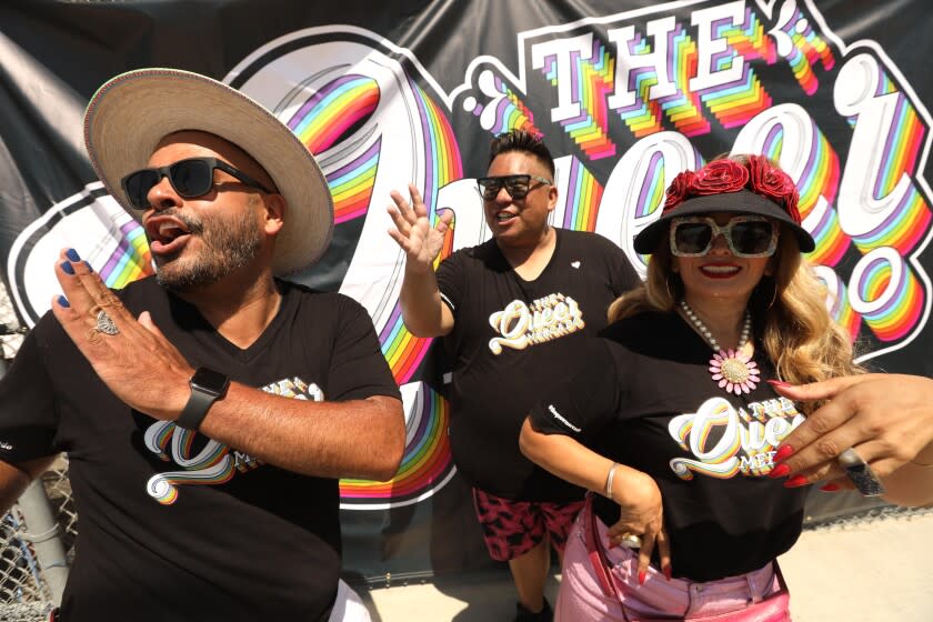 EAST LOS ANGELES, CA - JULY 16, 2022 - - Gaudencio Marquez, from left, Ryan Montez and Diana Diaz, co-founders of The Queer Mercado, wave to friends at the monthly market near the Hilda L. Solis Learning Academy on Humphreys Avenue in East Los Angeles on July 16, 2022. The Queer Mercado is celebrating a one-year anniversary and happens every third Saturday of the month. It features art, food and music catering to Latinos and LGBTQ+ community. (Genaro Molina / Los Angeles Times)