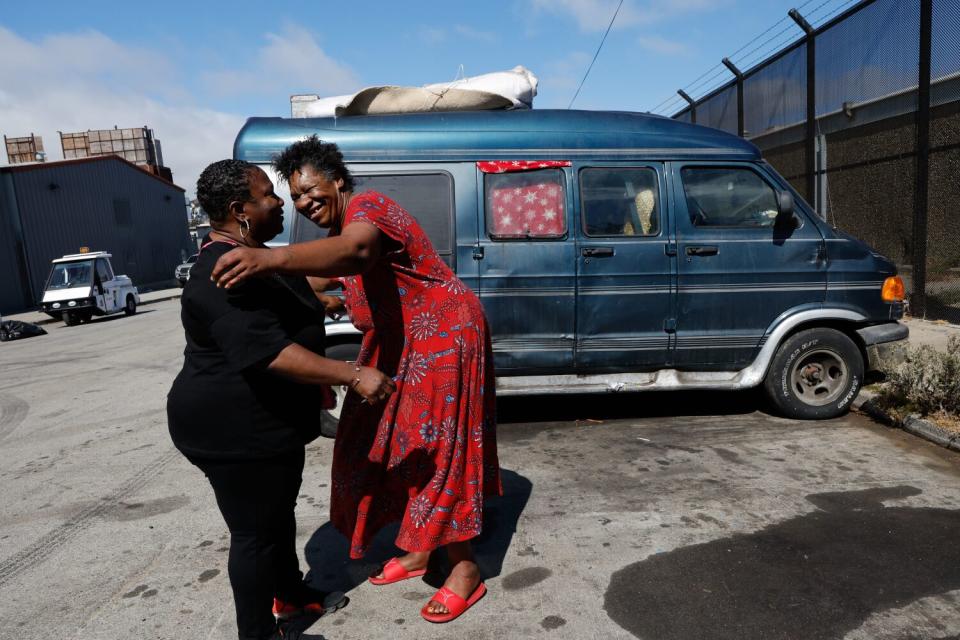 Cynthia Scott of Catholic Charities, left, visits Tammie Haley, who lives in her van with her husband Bruce