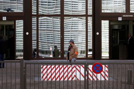 A security guard is pictured at the entrance of the European Union Council building after noxious gases were found in its kitchens in Brussels, Belgium October 13, 2017. REUTERS/Francois Lenoir