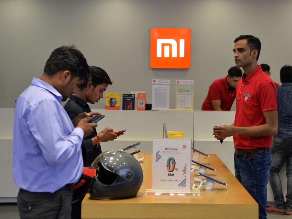 Customers inspect smartphones made by Xiaomi at a Mi store in Gurgaon.