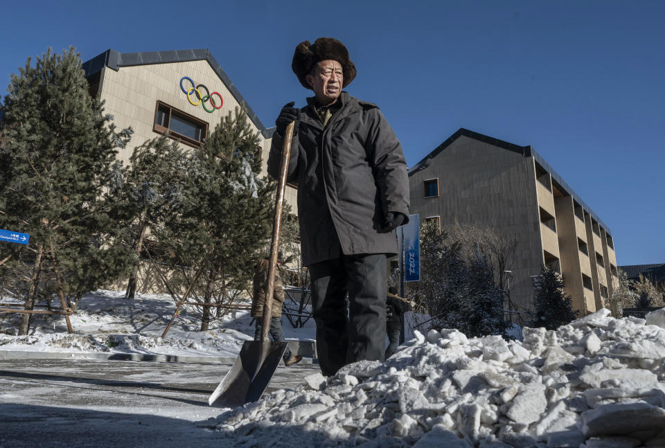 A worker pauses after shoveling artificial snow
