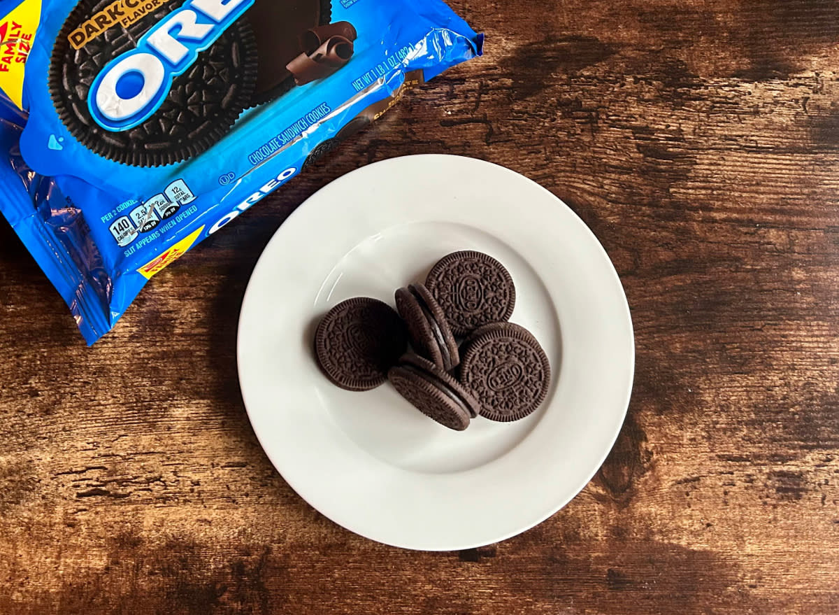 dark chocolate oreos on a plate next to a package of dark chocolate oreos