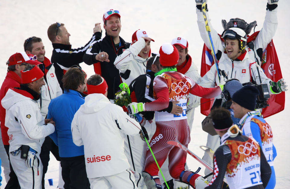 Men's supercombined gold medal winner Switzerland's Sandro Viletta, center right, is congratulated by teammates at the Alpine ski venue at the Sochi 2014 Winter Olympics, Friday, Feb. 14, 2014, in Krasnaya Polyana, Russia. (AP Photo/Gero Breloer)