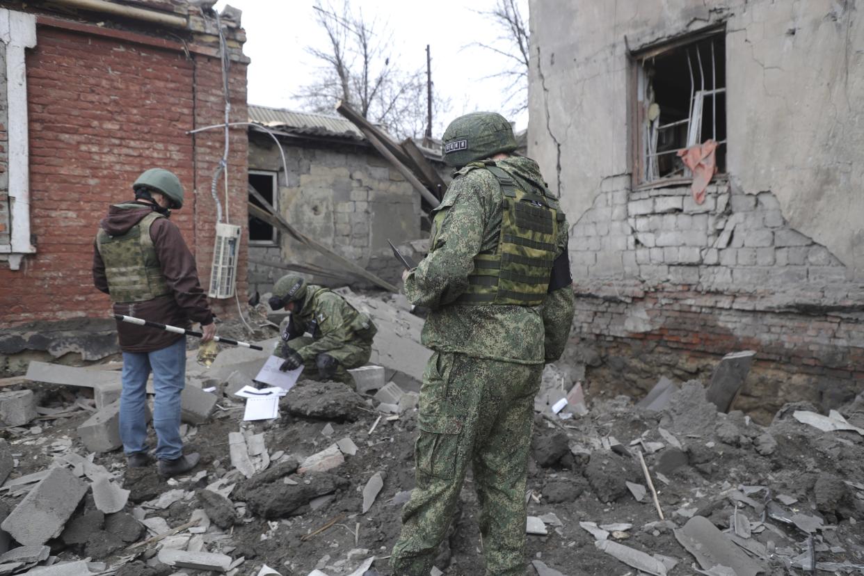 Investigators inspect a site of an apartment building after shelling by Ukrainian forces in Makiivka, Donetsk People's Republic, eastern Ukraine, Friday, Nov. 4, 2022. (AP Photo)