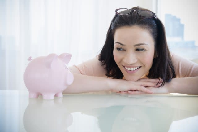 woman examining piggy bank