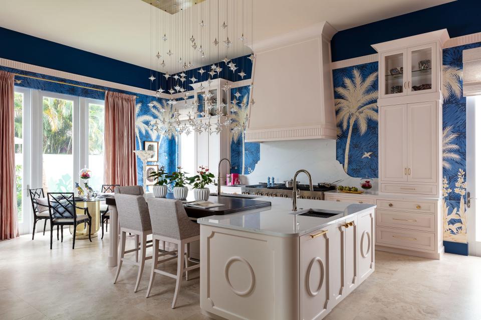 In the kitchen designed by Jim Dove Designs at the Kips Bay Decorator Show House Palm Beach, a Gracie wallpaper with palm trees and a deep blue background covers the walls.The fixtures and faucets are by Kohler.