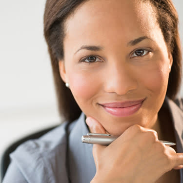 Confident--businesswoman-smiling-with-hand-on-chin_web